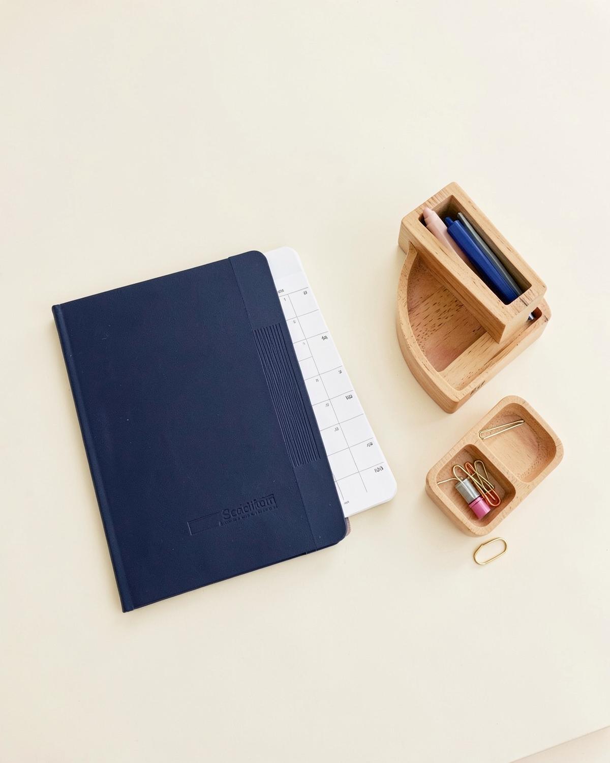 Carnet bleu navy, planner et organiseur en bois posés à plat